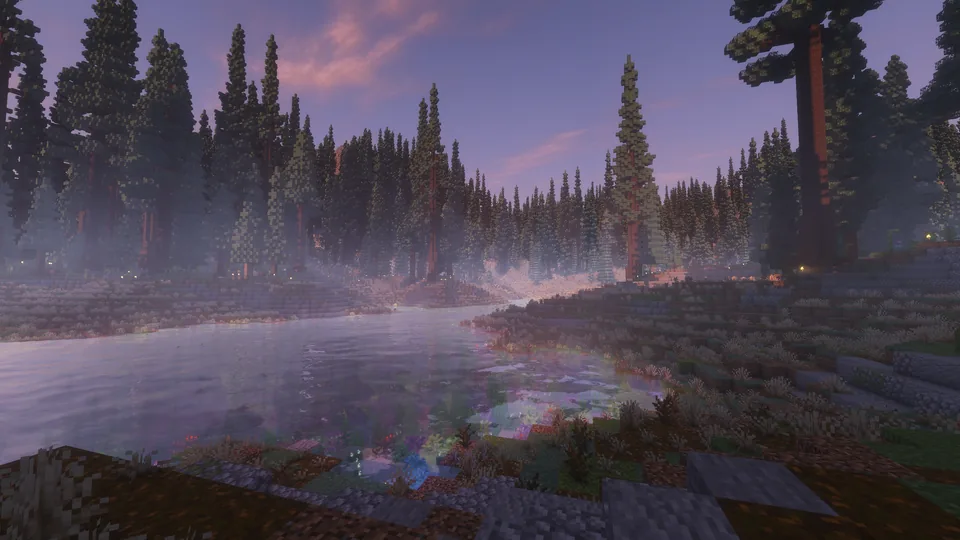 A river beside a rocky, flower-lined bank and misty conifers at dusk